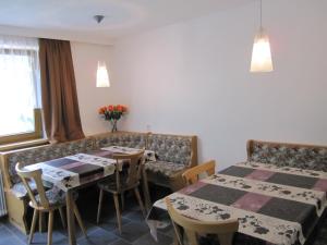 una habitación de hotel con 2 mesas y un sofá en Haus Arosa, en Kappl