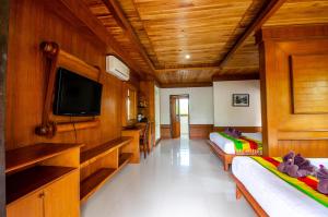 a large room with a bed and a tv at Khum Laanta Resort - SHA Extra Plus in Ko Lanta
