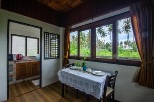 una sala da pranzo con tavolo e alcune finestre di Khum Laanta Resort - SHA Extra Plus a Ko Lanta