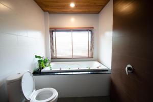 a bathroom with a toilet, sink, and tub at Khum Laanta Resort - SHA Extra Plus in Ko Lanta