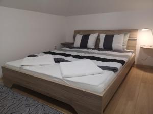 a large bed with white sheets and pillows on it at Edo in Visoko