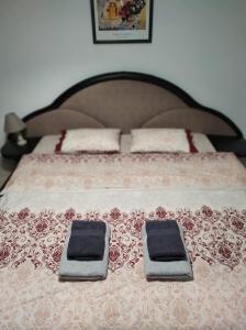 a bed with two pillows on top of it at Nice and cosy house 2 in Larisa