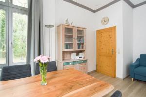 ein Wohnzimmer mit einem Holztisch und einer Vase mit Blumen in der Unterkunft Adlerhorst im Haus Seeadler in Zinnowitz + 8 Fotos