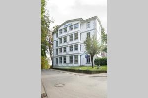 een wit gebouw met een bord aan de straatkant bij Wohnung Eule im Haus Seeadler in Zinnowitz