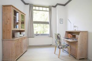 une cuisine avec un bureau, une chaise et une fenêtre dans l'établissement Wohnung Eule im Haus Seeadler, à Zinnowitz