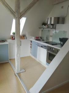 a kitchen with white counters and a staircase in a room at Ferienwohnung Hafenwestseite Neustadt in Neustadt in Holstein