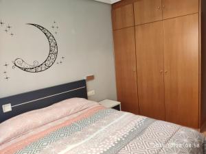 una camera da letto con un letto con una luna sul muro di RELAX, MAR Y MONTAÑA a Tavernes de Valldigna