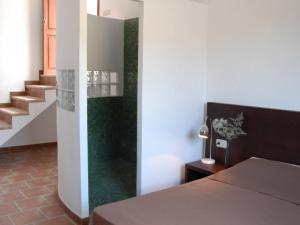 1 dormitorio con 1 cama y una escalera con alfombra verde en loftOtel canet en Esporles