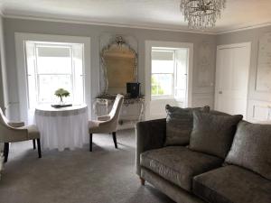 a living room with a couch and a table and a mirror at Branxholme Castle (Bed & Breakfast) in Hawick