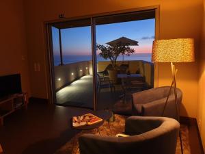 d'un salon avec une table et des chaises ainsi que d'un balcon. dans l'établissement Casa Atlantico Dachterrassengeschoss, à Ribeira Brava