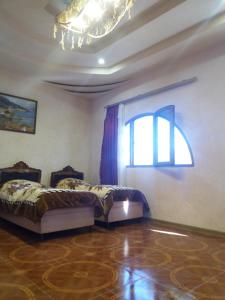 two beds in a room with a window at Saro B&B and Safari Tours in Tatʼev
