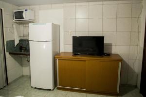 La cuisine est équipée d'un réfrigérateur blanc et d'un four micro-ondes. dans l'établissement Suíte Abreu Noronha, à Fernando de Noronha
