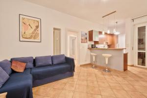ein Wohnzimmer mit einem blauen Sofa und einer Küche in der Unterkunft Piazza Statuto Elegant Apartment in Turin