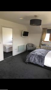 a bedroom with a bed and a tv on the wall at The Anchorage B and B in John O Groats