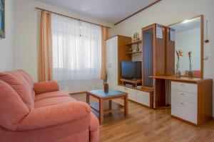 a living room with a couch and a television at Apartments Konta Vodice in Vodice