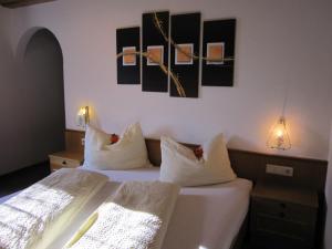 カップルにあるHaus Arosaの壁に絵画が飾られた客室内のベッド2台