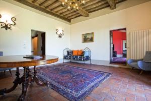 a living room with a table and a rug at Villa San Pietro in Cortona