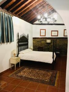 1 dormitorio con cama y lámpara de araña en HABITACIONES LAS TERMAS, en Guadix