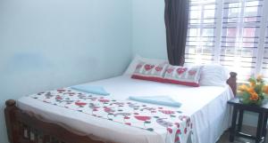 Bett in einem Zimmer mit Fenster in der Unterkunft Sili Homestay in Madikeri