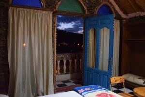 a bedroom with a blue door and a window at Hotel Leonor in Had Beni Chiker