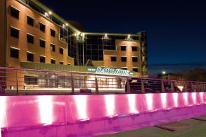 un edificio con un'insegna al neon di fronte di Dado Hotel International a Parma