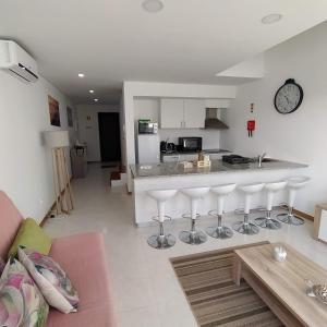 a kitchen and living room with a bar with stools at Helena's House in Ponta Delgada