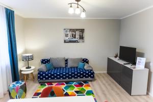 salon z kanapą i telewizorem w obiekcie Travel Homzzz Central Apartments - Tusnad w mieście Târgu Mureş