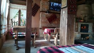 a living room with a table and a fireplace at Семеен хотел Скендерова Къща in Leshten