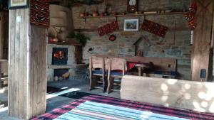 a living room with a fireplace and a table and chairs at Семеен хотел Скендерова Къща in Leshten