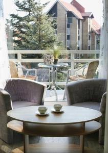 Pas Juste في نيدا: طاولة قهوة على شرفة مع كراسي وطاولة