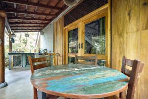 a dining room with a wooden table and chairs at Casa Vana Hiriketiya in Hiriketiya