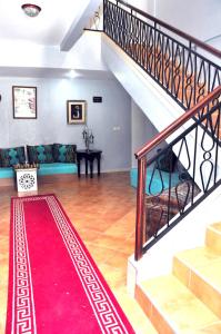 a living room with a staircase and a red rug at Hotel Ribis in Ait Melloul