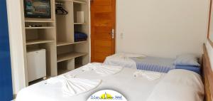 a bedroom with two beds and a closet at Mar e Praia Hotel in Ubatuba
