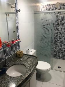 a bathroom with a toilet and a sink and a shower at Apartamento beira mar Intermares roupas de cama e AR CONDICIONADO COBRADO À PARTE in Cabedelo