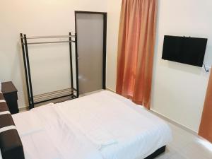 a small bedroom with a bed and a flat screen tv at OK FAMILY VILLA in Ipoh