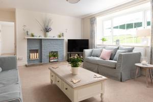 a living room with a couch and a fireplace at Braunton Farmhouse in Braunton