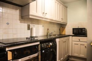 a kitchen with white cabinets and a sink and a dishwasher at Windmill Lane in Dublin