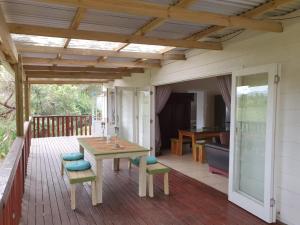 a patio with a table and chairs on a deck at WOODPECKER in Plettenberg Bay