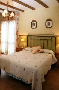 ein Schlafzimmer mit einem großen Bett mit einer weißen Decke in der Unterkunft LA PORTAZA in Vera de Moncayo