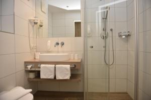 un bagno con doccia, lavandino e specchio di Hotel-Skischule Krallinger a Obertauern