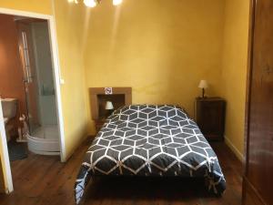 a bedroom with a black and white bed and a tub at Chez Jojo in Monein