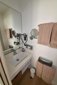 a bathroom with a sink and a toilet and a mirror at Hôtel de Provence in Cannes