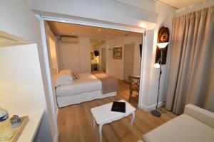a bedroom with a bed and a table and a couch at Hôtel de Provence in Cannes