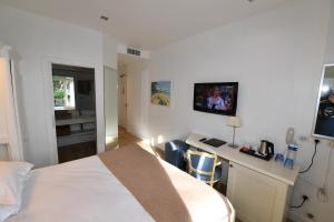 a hotel room with a bed and a desk with a computer at Hôtel de Provence in Cannes