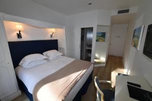 a bedroom with a large bed with a blue headboard at Hôtel de Provence in Cannes