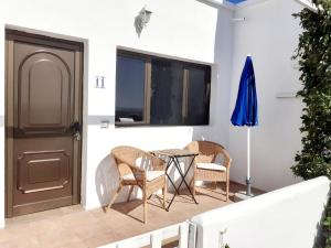 un patio con tavolo, sedie e finestra di Los Ancones Apartment a Costa Teguise