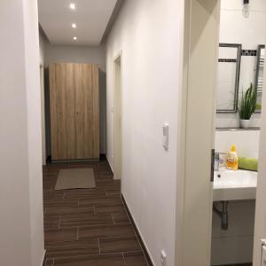 pasillo con baño con lavabo y espejo en New Private Rooms Fuerth en Fürth