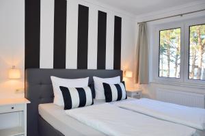 um quarto com uma cama com riscas pretas e brancas em Appartement-Villa Steinfurth em Binz