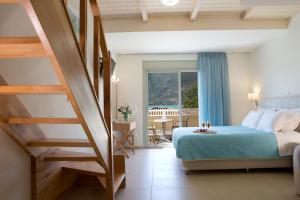 a hotel room with a bed and a staircase at Grand TheoNi Boutique Hotel & Spa in Vasiliki