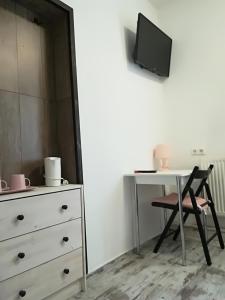 a bedroom with a dresser and a table and a tv at Boutique Family House LA in Füssen